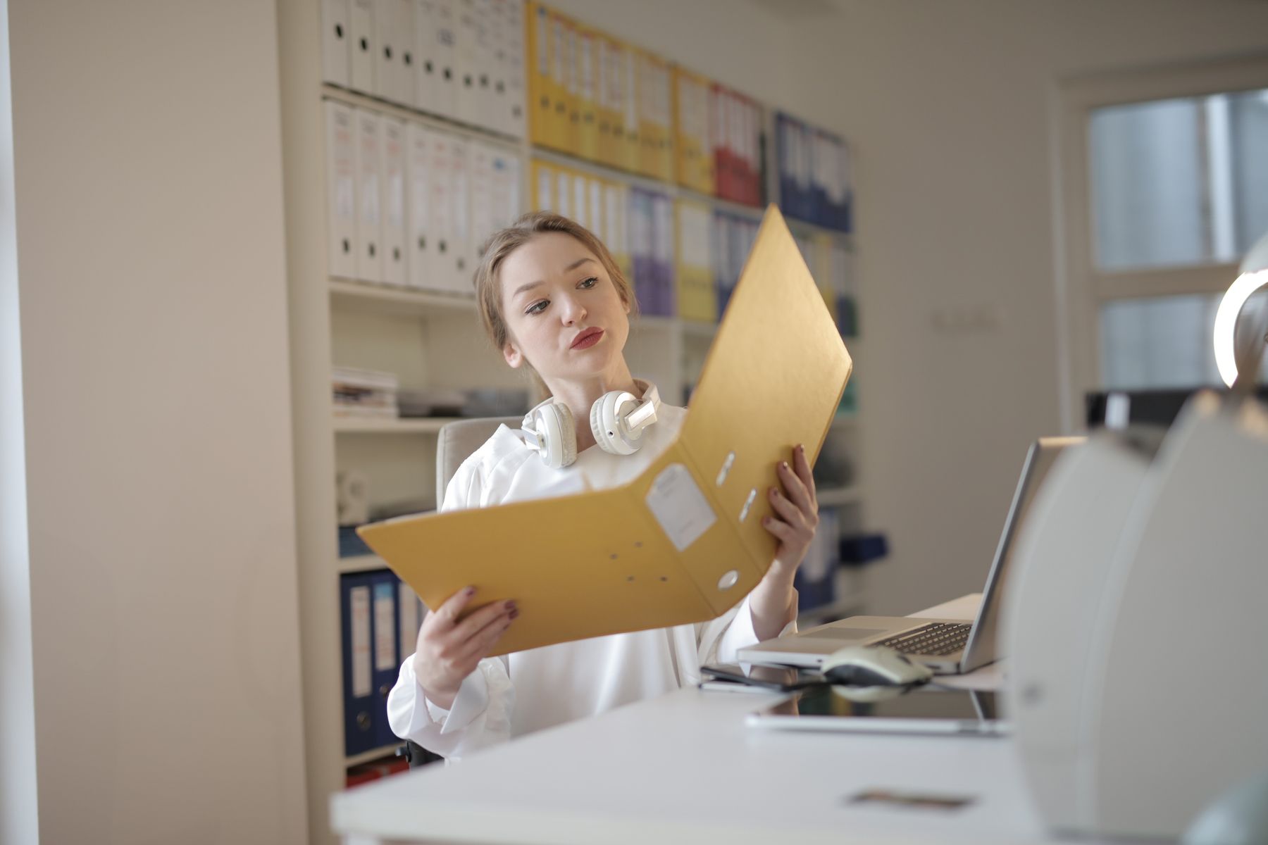 Two people reviewing records at a desk with bound ledgers